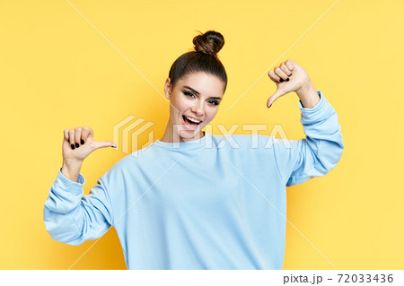 Young happy wman pointing to herself isolated over yellow background 72033436
