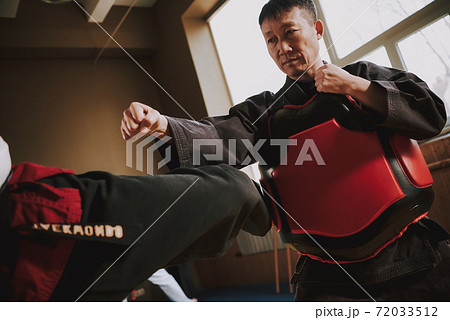 Man stands with a sparring partner.  72033512