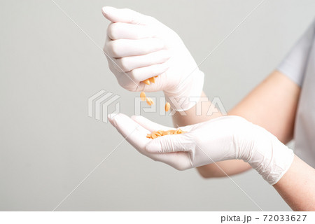 Hard wax beans in hands. 72033627