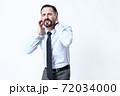 A man in a shirt stands and holds on to sore neck. 72034000