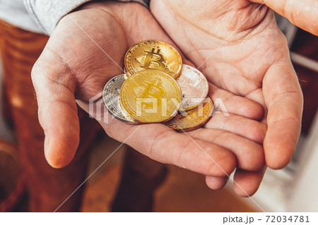 Man hand holding cryptocurrency golden and silver bitcoin coin. Electronic virtual money for web banking and international network payment. Symbol of crypto virtual currency. Mining concept. Man hand holding cryptocurrency golden and silver bitcoin coin. Electronic virtual money for web banking and international network payment. Symbol of crypto virtual currency. Mining concept. 72034781