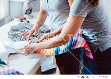 Hands on fabric pattern palette on studio table 72037338