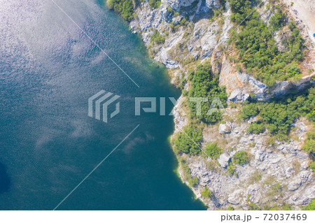 Aerial view of Grand Canyon Chonburi. Trucks dig coal mining or ore with black grunge ground in quarry with mountain hills. Nature landscape background in factory industry. Environment resources. 72037469