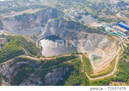 Aerial view of Grand Canyon Chonburi. Trucks dig coal mining or ore with black grunge ground in quarry with mountain hills. Nature landscape background in factory industry. Environment resources. 72037470