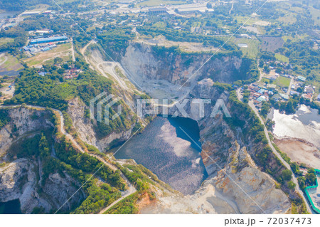 Aerial view of Grand Canyon Chonburi. Trucks dig coal mining or ore with black grunge ground in quarry with mountain hills. Nature landscape background in factory industry. Environment resources. 72037473