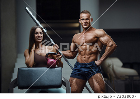 Sporty fitness couple working out in gym 72038007