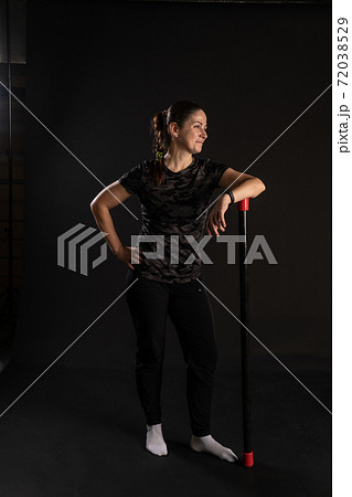 Fitness rests on the bodybar stretches the arms. Go in for sports on a black background with beautiful eyes 72038529