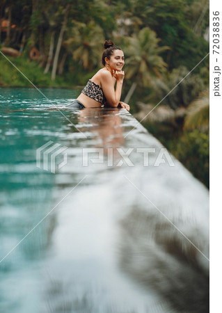 Woman in a swimming pool on a jungle view Woman in a swimming pool on a jungle view 72038836