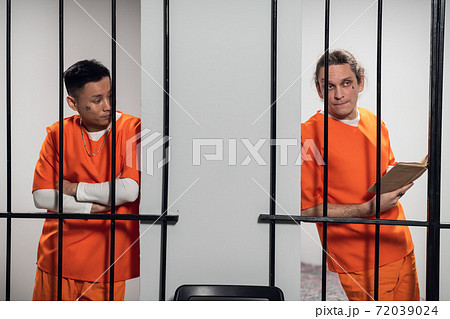 Two ethical prisoners talk through the bars of neighboring cells in the prison. Preparing to escape. Two ethical prisoners talk through the bars of neighboring cells in the prison. Preparing to escape. 72039024