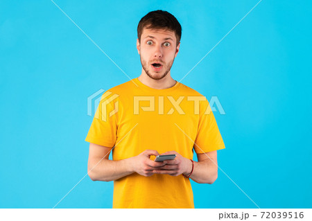 Surprised man using mobile phone at studio Surprised man using mobile phone at studio 72039516