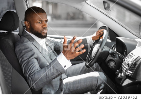 Stressed african american businessman yelling and gesturing while driving car 72039752