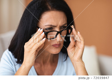 Mature Woman Squinting, Trying To Look Closer Through Eyeglasses 72039847