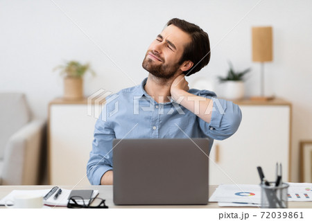 Man Touching Aching Neck Working On Laptop Sitting At Workplace Man Touching Aching Neck Working On Laptop Sitting At Workplace 72039861
