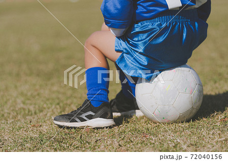 サッカーボールに座る子供の写真素材