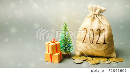 Money bag 2021, Christmas tree, and gifts. New Year or Xmas winter holiday. Accumulating money and planning a budget. Business and finance. Loans, deposit, credit. Promotions, offers 72041601