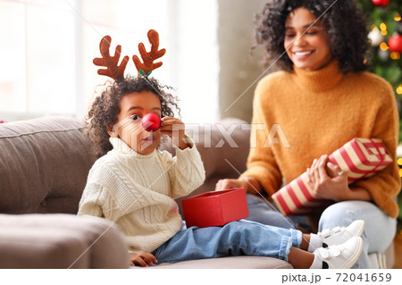 Ethnic mother playing with son in cozy room on Christmas day. Ethnic mother playing with son in cozy room on Christmas day. 72041659