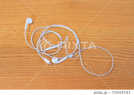机の上に置かれたイヤホン 72044591