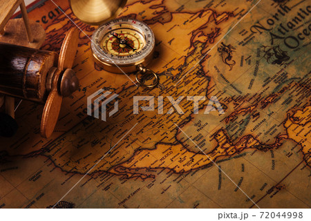Old compass discovery and wooden plane on vintage paper antique world map 72044998