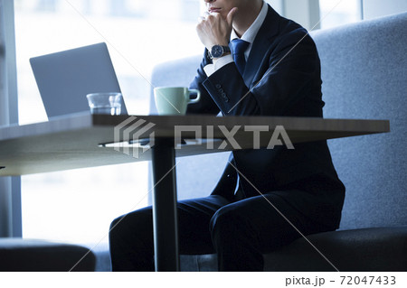 飲食店でテレワークする男性　 72047433