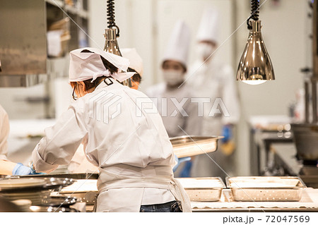 手袋とマスクをつけてキッチンで仕事をする人の画像 72047569