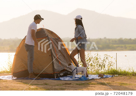 Young adult Asian couple pitch and set up tent for camping 72048179