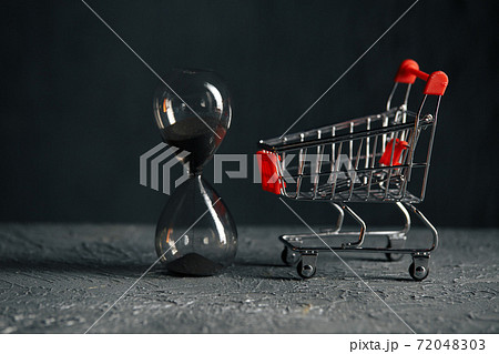 Time for shopping concept. Shopping cart and hourglass. Sale Time for shopping concept. Shopping cart and hourglass. Sale 72048303