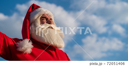 Close-up portrait of santa claus against the blue sky. Christmas time Close-up portrait of santa claus against the blue sky. Christmas time 72051406