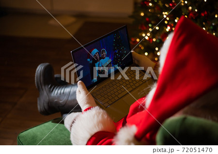 Happy mom and son talking to santa claus by video chat on a laptop. Woman and boy remotely wishes Merry Christmas 72051470