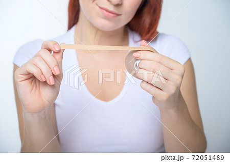 Female hands close-up with a plaster against facial wrinkles. Woman holds in her hands a tape for lifting the skin of the face. An unrecognizable woman rejuvenated with kinesio tapes. Female hands close-up with a plaster against facial wrinkles. Woman holds in her hands a tape for lifting the skin of the face. An unrecognizable woman rejuvenated with kinesio tapes. 72051489