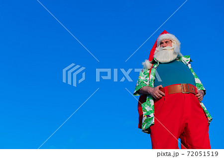 Santa claus in a hawaiian shirt on a blue background. 72051519