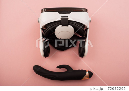 Clitoral vaginal black vibrator and virtual reality helmet on a pink background 72052292