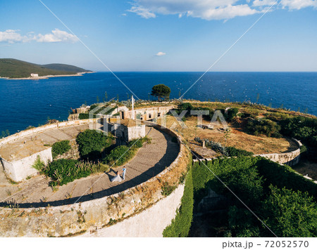 the bride and groom are circling on the roof of the ancient abandoned Arza fortress on the Mamula island 72052570