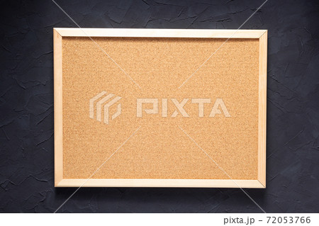 cork board and table near concrete wall 72053766