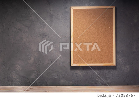 cork board and table near concrete wall 72053767