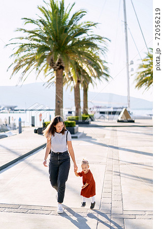 Mom and daughter are running and having fun on a boat pier by the sea Mom and daughter are running and having fun on a boat pier by the sea 72056219