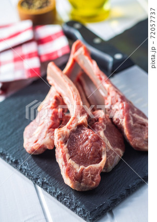 Slices raw lamb chops on stone cutting board 72057737