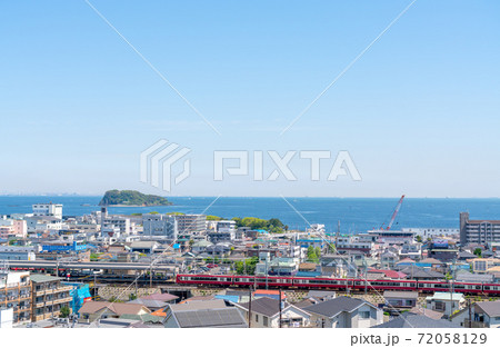 海沿いの住宅街を走る電車 72058129