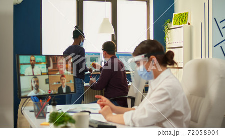 Businesswoman talking on video call wearing protection mask 72058904