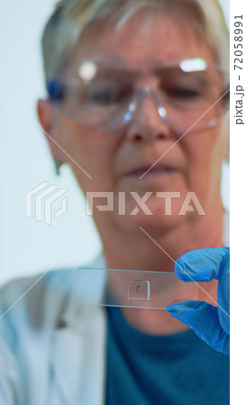 Close up of lab engineer analysing virus sample Close up of lab engineer analysing virus sample 72058991