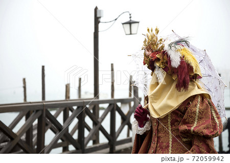 Woman with umbrella on the venetian lagoon background. Venetian carnival outfit Woman with umbrella on the venetian lagoon background. Venetian carnival outfit 72059942