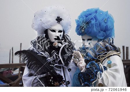 Two masks of the Venice carnival in similar costumes 72061946