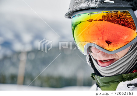 Close-up cropped snapshot of man wearing ski goggles with reflection of snowed slope. Close-up cropped snapshot of man wearing ski goggles with reflection of snowed slope. 72062263