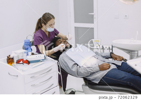 African patient in dentistry sitting in dental chair African patient in dentistry sitting in dental chair 72062329