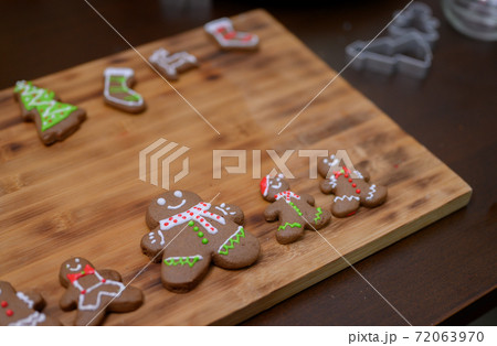 Homemade Xmas cookie for Christmas and Happy New Year. Woman cooking gingerbread with friend and Family on winter holiday at home. 72063970