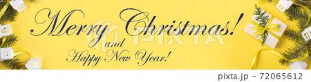 Christmas, New Year festive yellow banner with DIY gift box, green fir branches, Xmas lights white lodges and inscription Merry Christmas. Top view. Christmas holiday decorations. Copy space for text. 72065612