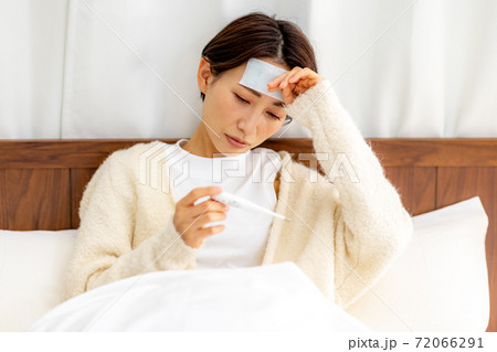 女性　体調不良　熱　ベッド 72066291