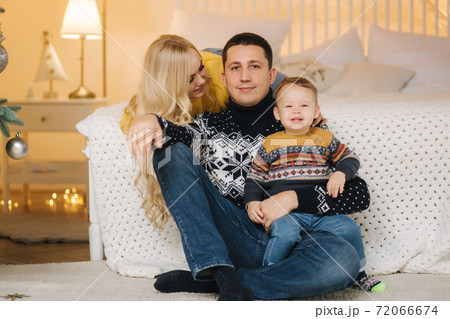 Young family spend time at home in Christmas time. Happy Mom, dad and son enjoyng love hugs, holidays people. Togetherness concept Young family spend time at home in Christmas time. Happy Mom, dad and son enjoyng love hugs, holidays people. Togetherness concept 72066674