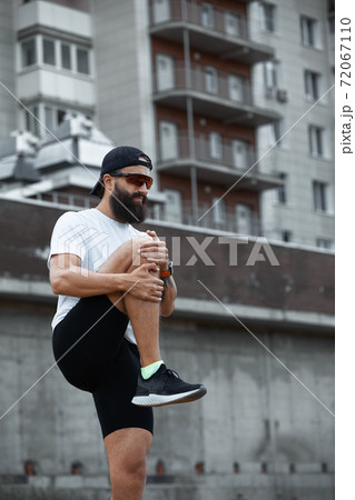 Bearded athletic man doing workout exercise in the outdoor gym in sunset Bearded athletic man doing workout exercise in the outdoor gym in sunset 72067110