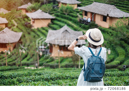 Happy tourist woman in white dress enjoy beautiful Tea garden.Traveler visiting in Ban Rak Thai village, Mae Hong Son, Thailand. travel, vacation and holiday concept Happy tourist woman in white dress enjoy beautiful Tea garden.Traveler visiting in Ban Rak Thai village, Mae Hong Son, Thailand. travel, vacation and holiday concept 72068186