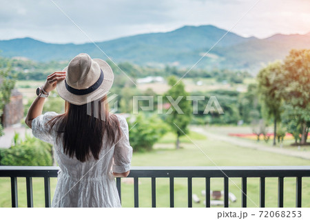Happy woman in white dress and hat looking beautiful Nature view. Relaxing, travel, nature, vacation and holiday concept Happy woman in white dress and hat looking beautiful Nature view. Relaxing, travel, nature, vacation and holiday concept 72068253